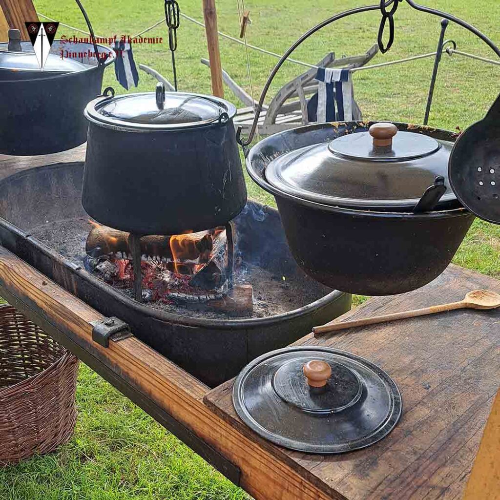 Die Töpfe voller Essen hängen über der Feuerstelle bereit